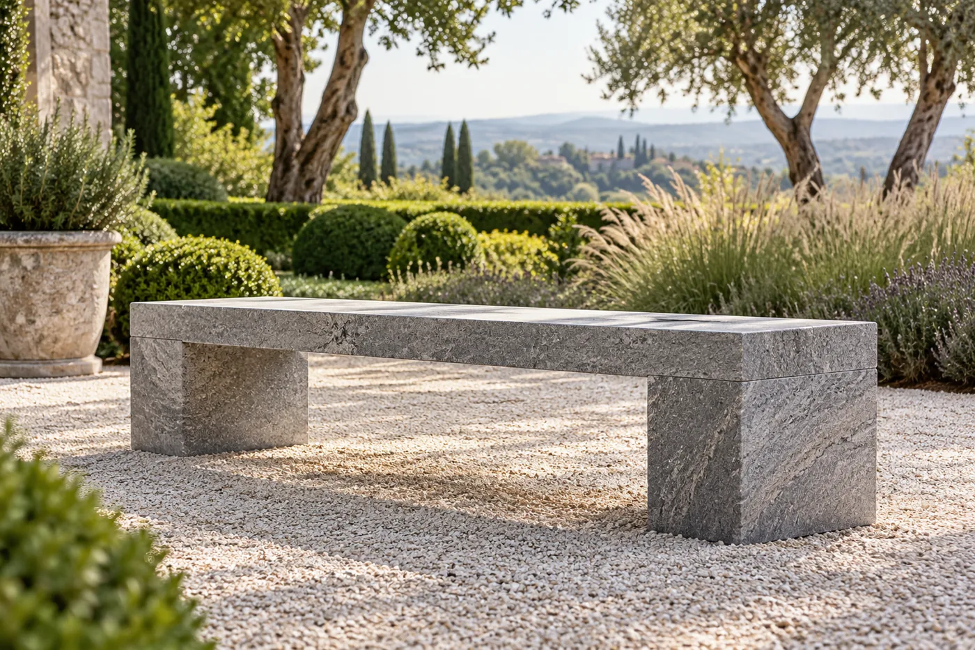 Gartenbank aus grauem Stein auf einem ebenen Kiesplatz