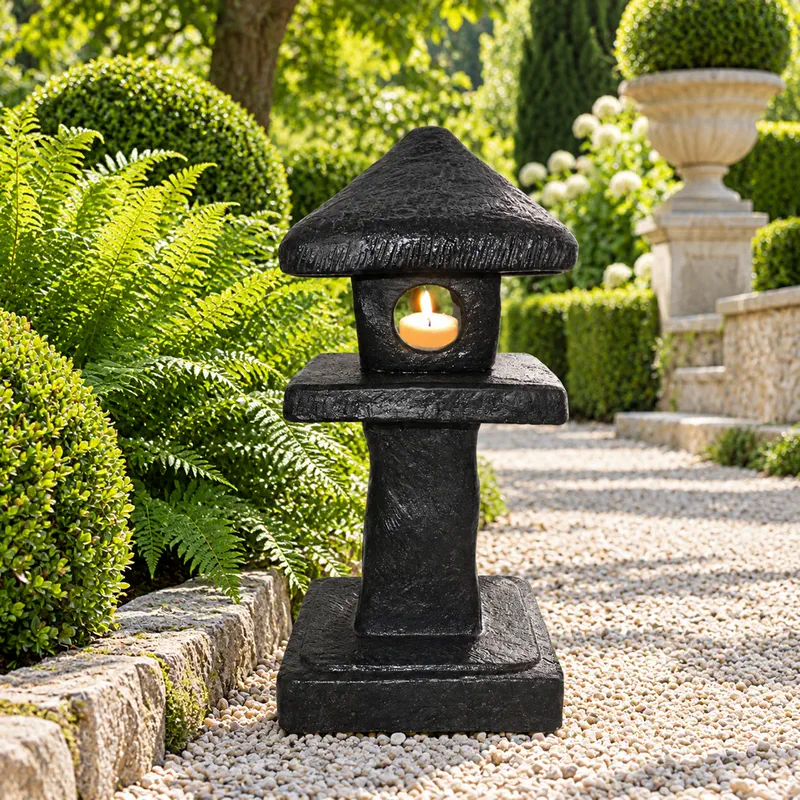 Japanische Steinlaterne an einem begrünten Gartenweg